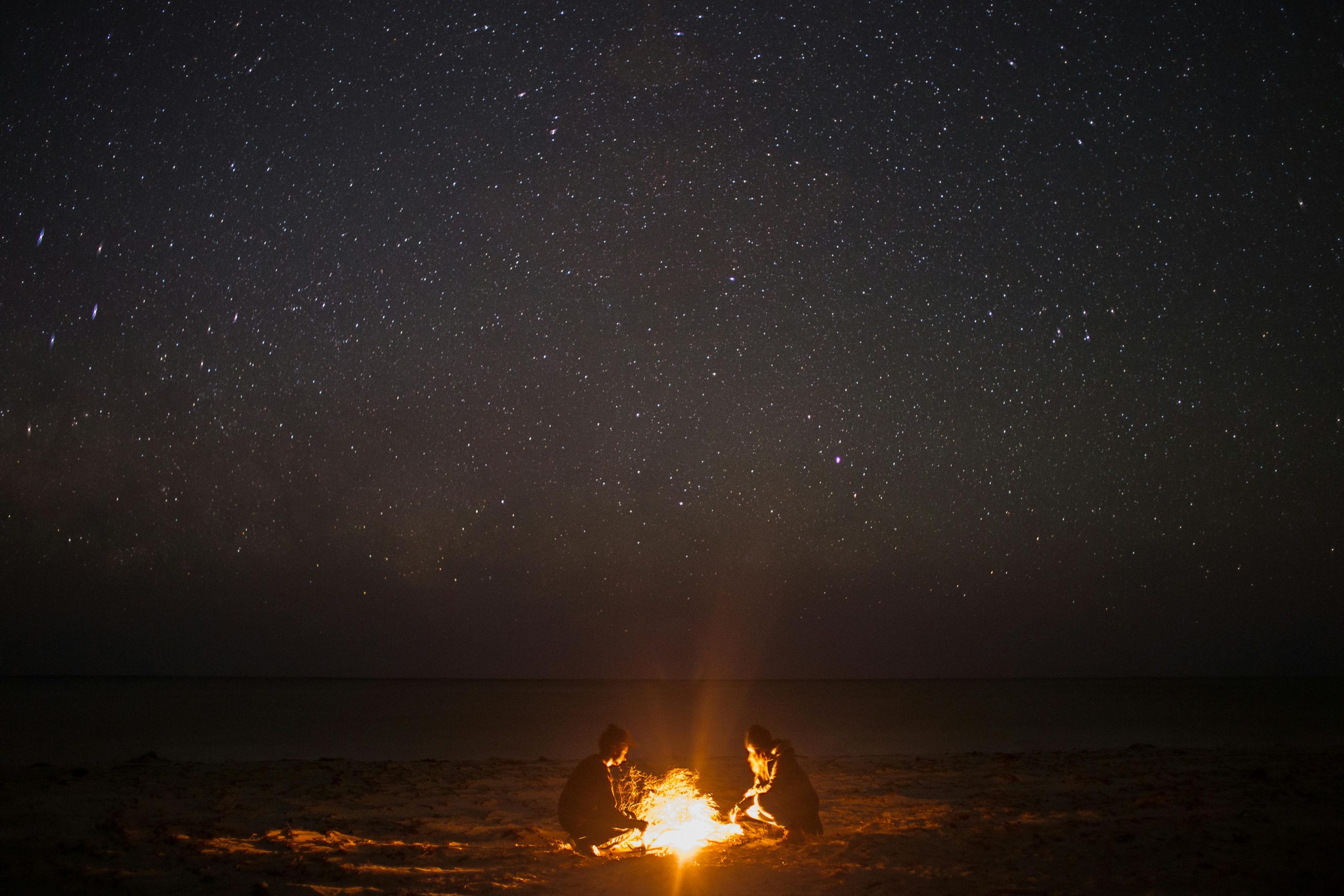 couple and on beach in the night sky bonfire